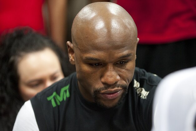 Apr 14, 2015; Las Vegas, NV, USA; Floyd Mayweather, Jr., looks on as his gloves are taped on before he performs a workout at Mayweather Boxing Club. Mandatory Credit: Stephen R. Sylvanie-USA TODAY Sports