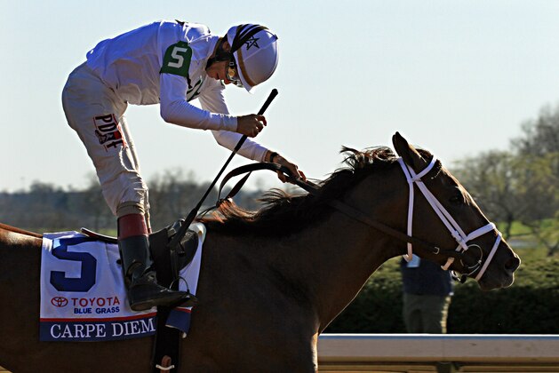 Jockey John Velazquez celebrates his victory aboard heavy favorite Carpe Diem in the Blue Grass Stakes horse race at Keeneland Race Course in Lexington, Ky., Saturday, April. 4, 2015. (AP Photo/Garry Jones)
