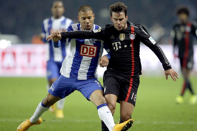 Berlin's Marcel Ndjeng from Cameroon, left, and Bayern's Juan Bernat from Spain, right, challenge for the ball during the German Bundesliga soccer match between Hertha BSC Berlin  and FC Bayern Munich at the Olympic stadium in Berlin, Germany, Saturday, Nov. 29, 2014. (AP Photo/Michael Sohn)