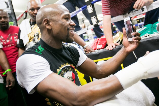 Floyd Mayweather gets a FaceTime call from Tom Brady before hi media workout at his Mayweather Boxing Club on Tuesday, April 14, 2015 in Las Vegas. (AP Photo/John Salangsang)