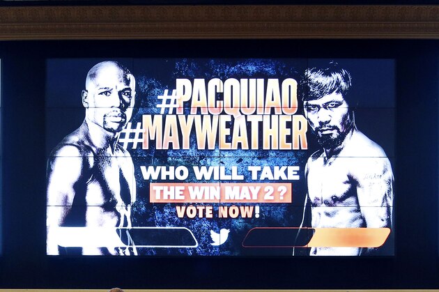 An advertisement for a fight between Floyd Mayweather Jr. and Manny Pacquiao is seen on a screen as people wait to check in at the MGM Grand Friday, April 24, 2015, in Las Vegas. The fight is scheduled to take place May 2 at the hotel and casino. (AP Photo/John Locher)