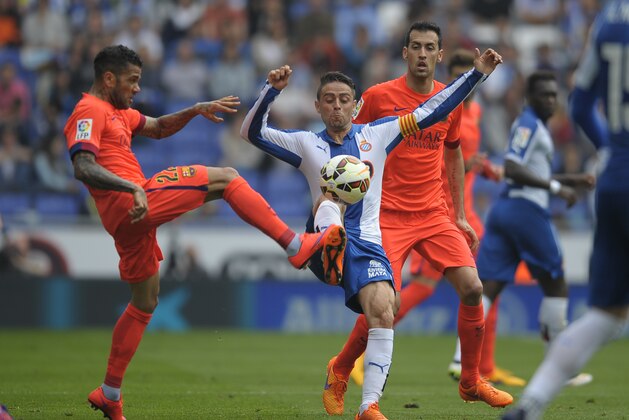 FC Barcelona's Dani Alvez, from Brazil, left, duels for the ball against Espanyol's Sergio Garcia, second left, during a Spanish La Liga soccer match at Cornella-El Prat stadium in Cornella Llobregat, Spain, Saturday, April 25, 2015. (AP Photo/Manu Fernandez)