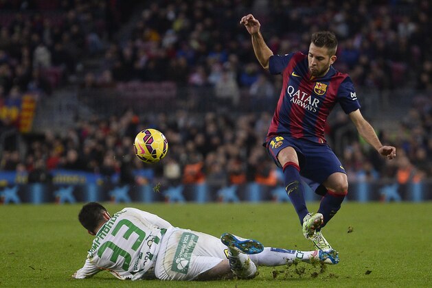 FC Barcelona's Jordi Alba, right, duels for the ball against Cordoba's Edu Campabadal during a Spanish La Liga soccer match at the Camp Nou stadium in Barcelona, Spain, Saturday, Dec. 20, 2014. (AP Photo/Manu Fernandez)