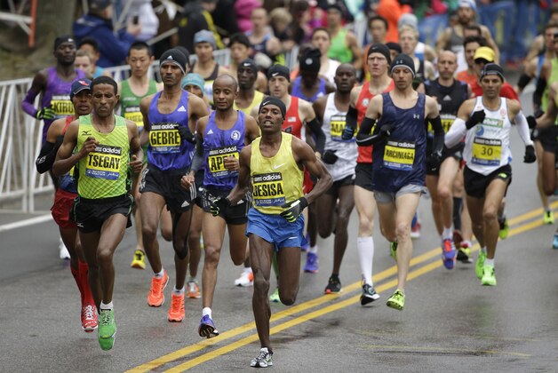 Lelisa Desisa, of Ethiopia, center, runs with the pack through Hopkinton, Mass., en route to a win in the Boston Marathon, Monday, April 20, 2015. (AP Photo/Steven Senne)