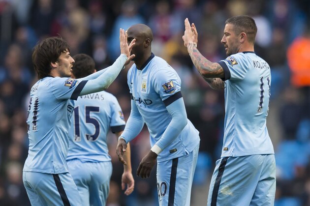 Manchester City's Aleksandar Kolarov, right, celebrates with teammates after scoring from a free kick during the English Premier League soccer match between Manchester City and Aston Villa at the Etihad Stadium, Manchester, England, Saturday April 25, 2015. (AP Photo/Jon Super)