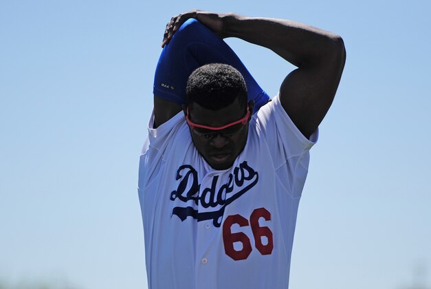 Mar 25, 2015; Phoenix, AZ, USA; Los Angeles Dodgers right fielder Yasiel Puig (66) warms up prior to facing the San Diego Padres at Camelback Ranch. Mandatory Credit: Joe Camporeale-USA TODAY Sports