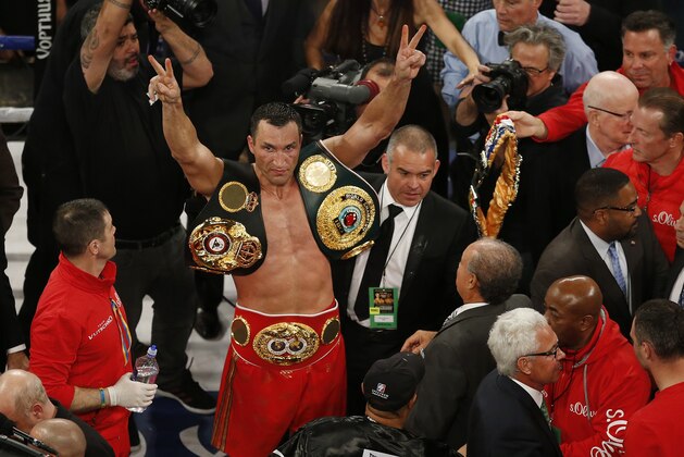 Wladimir Klitschko, center left, of Ukraine, holds his belts and gestures after defeating Bryant Jennings by decision in a heayyweight boxing bout, early Sunday, April 26, 2015, in New York. (AP Photo/Julio Cortez)