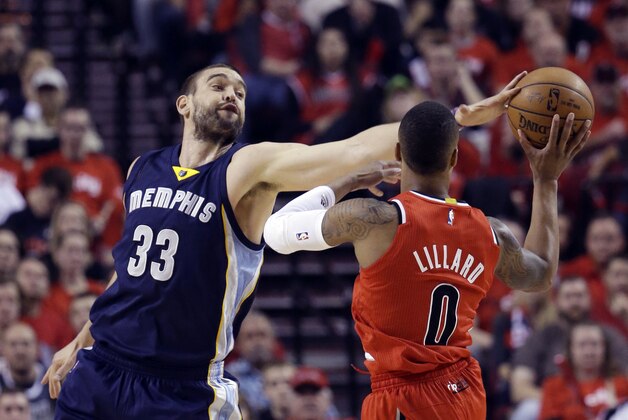 Memphis Grizzlies center Marc Gasol, left, gets a piece of the ball while defending Portland Trail Blazers guard Damian Lillard during the first half of Game 3 of a first-round NBA basketball playoff series in Portland, Ore., Saturday, April 25, 2015. (AP Photo/Don Ryan)