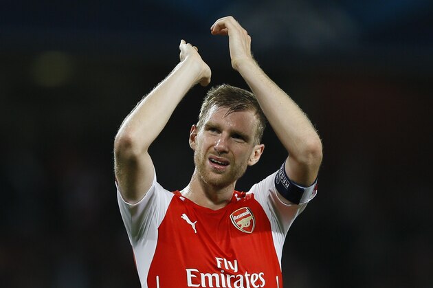 Arsenal's Per Mertesacker applauds the fans at the end of their second leg Champions League qualifying soccer match between Arsenal and Besiktas at Emirates Stadium in London Wednesday, Aug. 27, 2014. Arsenal won the game 1-0. (AP Photo/Kirsty Wigglesworth)