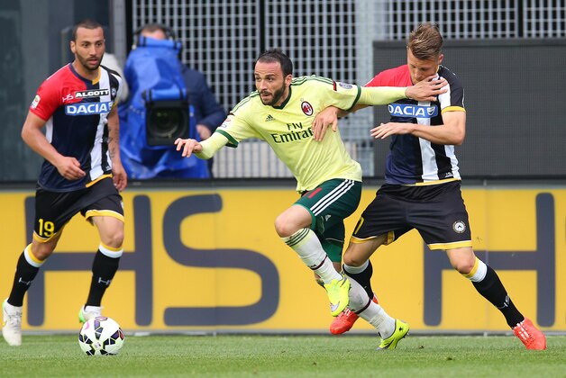 Milan's Giampaolo Pazzini, center, and Udinese's Silvan Widmer fight for the ball during a Serie A soccer match between Udinese and Milan at the Friuli Stadium in Udine, Italy, Saturday, April 25, 2015. (AP Photo/Paolo Giovannini)
