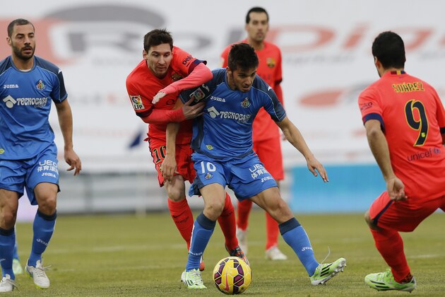 Getafe’s Sarabia, right, duels for the ball with Barcelona’s Lionel Messi during a Spanish La Liga soccer match between Getafe and Barcelona, at the Coliseum Alfonso Perez stadium in Madrid, Spain, Saturday, Dec. 13, 2014 . (AP Photo/Daniel Ochoa de Olza)