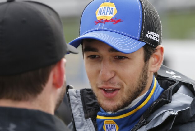 Spring Cup driver Chase Elliott talks to a crew member prior to qualifying at the Martinsville Speedway in Martinsville, Va., Friday, March 27, 2015. Rain delayed the practice and qualifying for Sunday's STP 500 Sprint Cup race.  (AP Photo/Steve Helber)