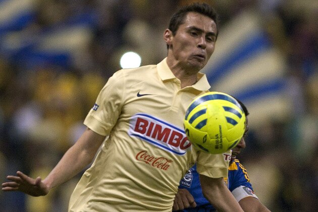 America's Paul Aguilar, left, and Tigres' Egidio Arevalo jump for the ball during a Mexican soccer league match in Mexico City, Saturday, Jan. 31, 2015. (AP Photo/Christian Palma)