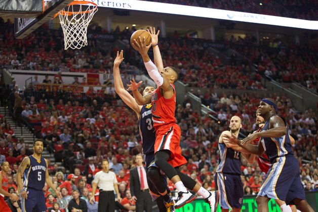 Apr 25, 2015; Portland, OR, USA; Portland Trail Blazers guard Damian Lillard (0) goes to the basket over Memphis Grizzlies center Marc Gasol (33) in game three of the first round of the NBA Playoffs at Moda Center at the Rose Quarter. Mandatory Credit: Jaime Valdez-USA TODAY Sports