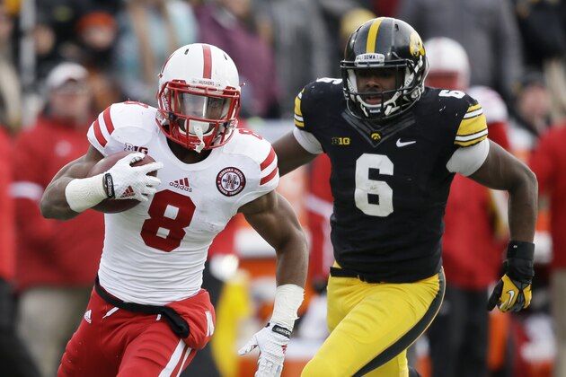 Nebraska running back Ameer Abdullah (8) runs from Iowa linebacker Reggie Spearman during the second half of an NCAA college football game, Friday, Nov. 28, 2014, in Iowa City, Iowa. Nebraska won 37-34 in overtime. (AP Photo/Charlie Neibergall)