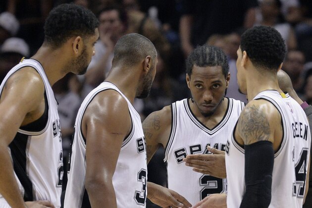 San Antonio Spurs players Tim Duncan (from left), Boris Diaw, of France, Kawhi Leonard, and Danny Green talk on the court during the second half of Game 4 in an NBA basketball first-round playoff series against the Los Angeles Clippers, Sunday, April 26, 2015, in San Antonio. Los Angeles won 114-105. (AP Photo/Darren Abate)
