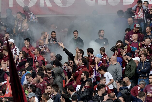 Smoke billows among Torino supporters prior to a Serie A soccer match between Torino and Juventus, at the Turin Olympic stadium, Italy, Sunday, April 26, 2015. Fireworks have exploded inside the stadium during the Torino-Juventus derby, injuring multiple fans. Before the match, Torino fans attacked the bus carrying Juve's players to the stadium, breaking a window. (AP Photo/Massimo Pinca)