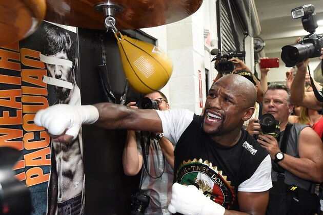 LAS VEGAS, NV - APRIL 14:  WBC/WBA welterweight champion Floyd Mayweather Jr. hits a speed bag as he works out in front of a poster of WBO welterweight champion Manny Pacquiao with his eyes and mouth taped over at the Mayweather Boxing Club on April 14, 2015 in Las Vegas, Nevada. Mayweather will face Pacquiao in a unification bout on May 2, 2015 in Las Vegas.  (Photo by Ethan Miller/Getty Images)