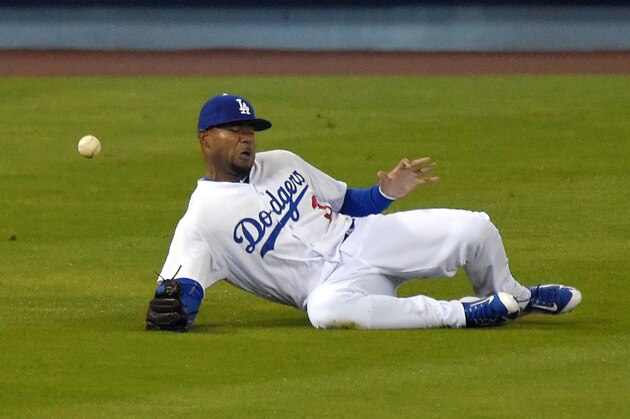 Los Angeles Dodgers left fielder Carl Crawford can't get to a ball hit for an RBI triple by San Diego Padres' Justin Upton during the first inning of a baseball game, Tuesday, April 7, 2015, in Los Angeles. (AP Photo/Mark J. Terrill)