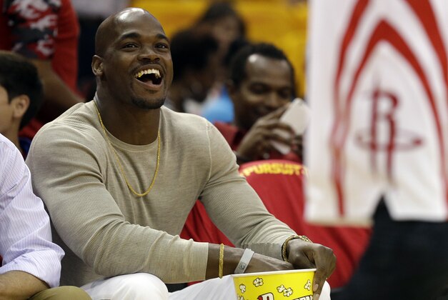 Adrian Peterson waits for the start of Game 5 in the first round of the NBA basketball playoffs between the Houston Rockets and Dallas Mavericks Tuesday, April 28, 2015, in Houston. (AP Photo/David J. Phillip)
