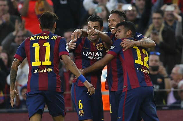 Barcelona's Xavi Hernandez, center, celebrates scoring his side's 4th goal with teammates during a Spanish La Liga soccer match between F.C. Barcelona and Getafe at the Camp Nou stadium in Barcelona, Spain, Tuesday, April 28, 2015. (AP Photo/Emilio Morenatti)