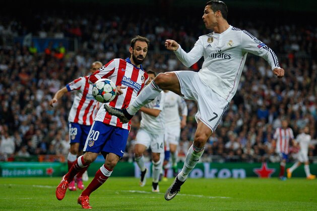 MADRID, SPAIN - APRIL 22:  Cristiano Ronaldo of Real Madrid CF jumps for the ball ahead of Juanfran of Atletico Madrid during the UEFA Champions League quarter-final second leg match between Real Madrid CF and Club Atletico de Madrid at Bernabeu on April 22, 2015 in Madrid, Spain.  (Photo by Gonzalo Arroyo Moreno/Getty Images)