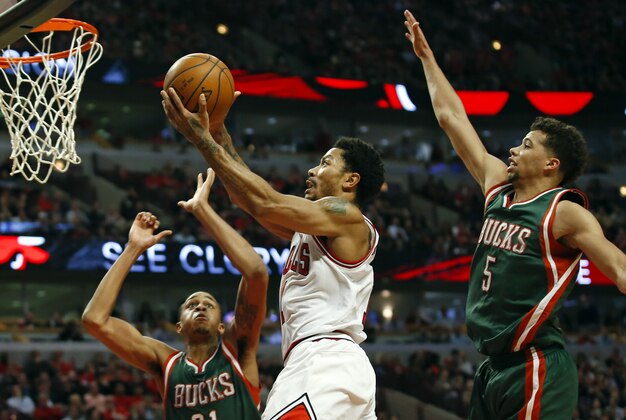 Apr 27, 2015; Chicago, IL, USA; Chicago Bulls guard Derrick Rose (1) goes to the basket between Milwaukee Bucks center John Henson (31) and guard Michael Carter-Williams (5) in game five of the first round of the 2015 NBA Playoffs at United Center. The Bucks won 94-88. Mandatory Credit: Kamil Krzaczynski-USA TODAY Sports