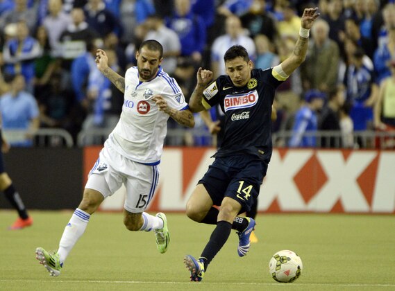 Apr 29, 2015; Montreal, Quebec, Canada; Club America midfielder Rubens Sambueza (14) plays the ball and Montreal Impact forward Andres Romero (15) defends during the first half of the second leg of the CONCACAF Champions League final at Olympic Stadium. Mandatory Credit: Eric Bolte-USA TODAY Sports