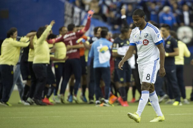 Montreal Impact midfielder Patrice Bernier walks off the pitch as members of Club America celebrate their 4-2 win in the CONCACAF final Wednesday, April 29, 2015, in Montreal. (Paul Chiasson/The Canadian Press via AP) MANDATORY CREDIT