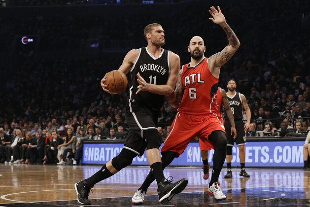 Brooklyn Nets center Brook Lopez (11) drives to the basket against Atlanta Hawks forward Pero Antic during the first half in Game 3 of a first-round NBA basketball playoff series, Saturday, April 25, 2015, at  New York.  (AP Photo/Mary Altaffer)