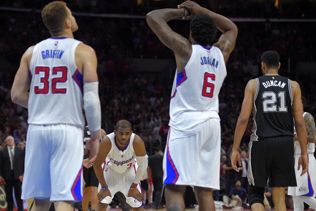 Los Angeles Clippers forward Blake Griffin, left, and guard Chris Paul, second from left, and center DeAndre Jordan, second from right, react as San Antonio Spurs forward Tim Duncan walks away after Jordan was called for offensive basket interference in the final seconds of Game 5 of a first-round NBA basketball playoff series, Tuesday, April 28, 2015, in Los Angeles. The Spurs won 111-107. (AP Photo/Mark J. Terrill)