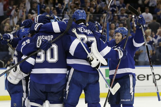Tampa Bay Lightning players, from left, Nikita Kucherov (86), of Russia, Ben Bishop (30), Victor Hedman (77), of Sweden, and Tyler Johnson celebrate their 2-0 win over the Detroit Red Wings in Game 7 of a first-round NHL Stanley Cup hockey playoff series Wednesday, April 29, 2015, in Tampa, Fla. (AP Photo/Chris O'Meara)
