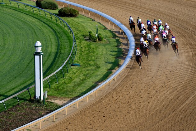 LOUISVILLE, KY - MAY 03:  The field of horses rounds the first turn during the 140th running of the Kentucky Derby at Churchill Downs on May 3, 2014 in Louisville, Kentucky.  (Photo by Jamie Squire/Getty Images)