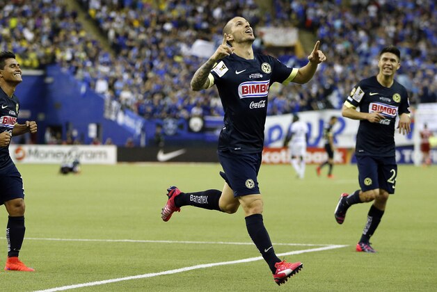 Club America forward Dario Benedetto, center, celebrates after scoring his third goal of the match against the Montreal Impact during the second half of the CONCACAF Champions League final game, Wednesday, April 29, 2015, in Montreal. Club America won 4-2. (AP Photo/Julio Cortez)