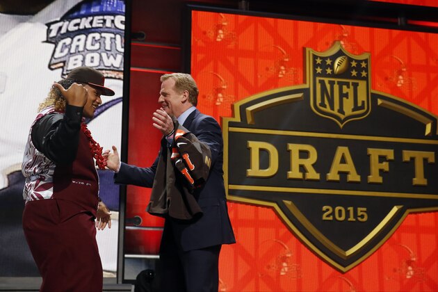 Washington defensive lineman Danny Shelton celebrates with NFL commissioner Roger Goodell after being selected by the Cleveland Browns as the 12th pick in the first round of the 2015 NFL Draft,  Thursday, April 30, 2015, in Chicago. (AP Photo/Charles Rex Arbogast)
