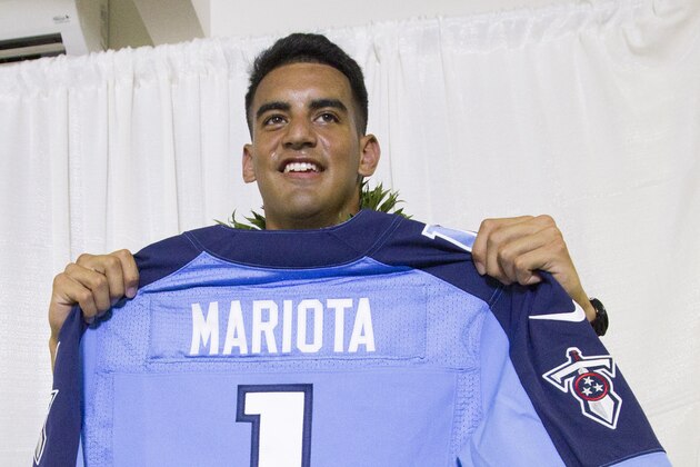 Former Oregon quarterback Marcus Mariota holds up his Tennessee Titians jersey for the media after being selected in the first round with the second pick by the Tennessee Titans on NFL Draft Day Thursday, April 30, 2015, in Honolulu. Mariota along with his family and friends gathered at the Saint Louis Alumni Clubhouse to celebrate his selection in the NFL Draft. (AP Photo/Eugene Tanner)