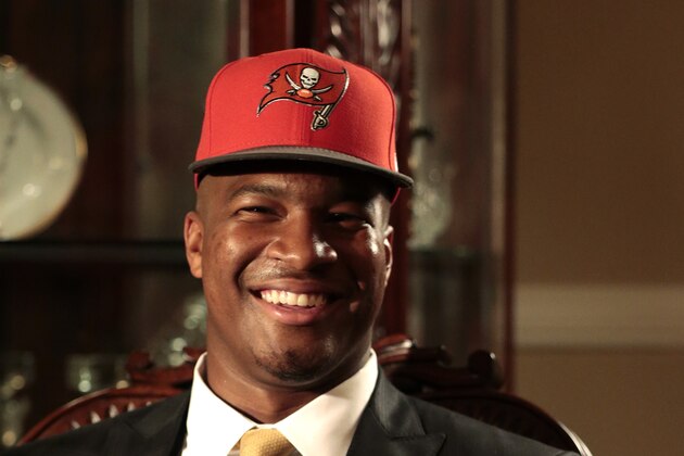 Jameis Winston poses with a Tamp Bay Buccaneers cap and NFL football after he was selected as the number one draft pick, Thursday, April 30, 2015, in Bessemer, Ala. (AP Photo/Butch Dill)