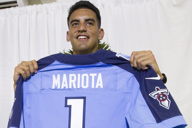 Former Oregon quarterback Marcus Mariota holds up his Tennessee Titians jersey for the media after being selected in the first round with the second pick by the Tennessee Titans on NFL Draft Day Thursday, April 30, 2015, in Honolulu. Mariota along with his family and friends gathered at the Saint Louis Alumni Clubhouse to celebrate his selection in the NFL Draft. (AP Photo/Eugene Tanner)