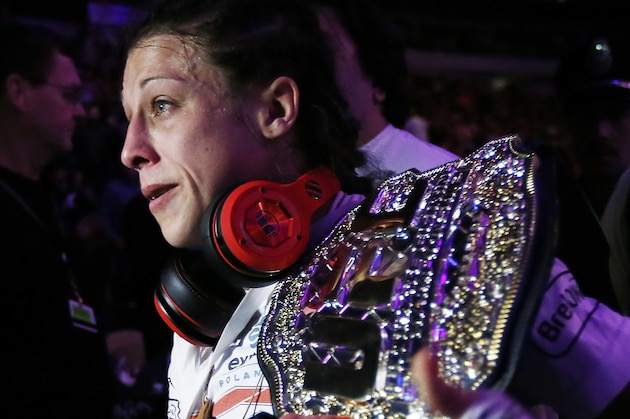 Joanna Jedrzejczyk, of Poland, leaves the ring with her championship belt after a women's strawweight UFC 185 mixed martial arts title bout against Carla Esparza, Saturday, March 14, 2015, in Dallas. Jedrzejczyk won by a TKO in two rounds. (AP Photo/Brandon Wade)