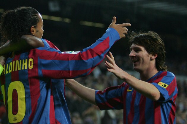 MADRID, SPAIN - NOVEMBER 19:  Ronaldinho (L) of  Barcelona celebrates with Lionel Messi after scoring a goal during the Primera Liga match between Real Madrid and F.C. Barcelona at the Bernabeu on November 19, 2005 in Madrid, Spain.  (Photo by Denis Doyle/Getty Images)