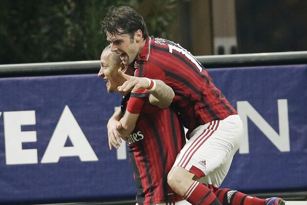 AC Milan's Philippe Mexes, left, celebrates with his teammate Andrea Poli after scoring during the Serie A soccer match between AC Milan and Cagliari at the San Siro stadium in Milan, Italy, Saturday, March 21, 2015. (AP Photo/Antonio Calanni)