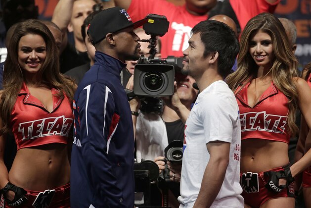 Floyd Mayweather Jr., left, and Manny Pacquiao pose during their weigh-in on Friday, May 1, 2015 in Las Vegas. The world weltherweight title fight between Mayweather Jr. and Pacquiao is scheduled for May 2. (AP Photo/Chris Carlson)