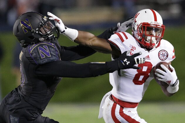Nebraska running back Ameer Abdullah (8) runs with the ball against Northwestern safety Traveon Henry during the first half of an NCAA college football game in Evanston, Ill., Saturday, Oct. 18, 2014. (AP Photo/Nam Y. Huh)