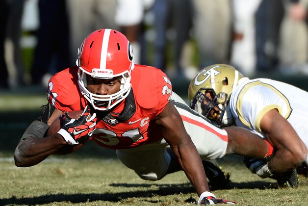 Georgia Tech's Chris Milton, right, brings down Georgia wide receiver Chris Conley (31) during the second half of an NCAA college football game Saturday, Nov. 29, 2014, in Athens, Ga. Georgia Tech won 30-24 in overtime. (AP Photo/David Tulis)