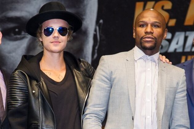 Boxer Floyd Mayweather Jr., right, meets Justin Bieber after a news conference, Wednesday, March 11, 2015, in Los Angeles. Mayweather is scheduled to fight Manny Pacquiao, of the Philippines, in Las Vegas on May 2. (Photo by John Salangsang/Invision/AP)