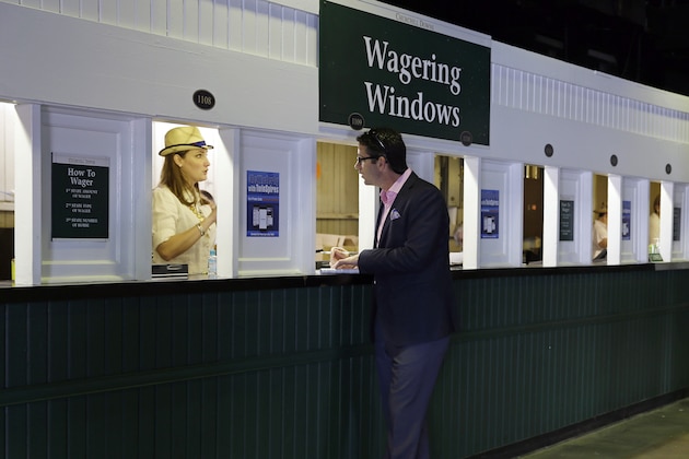 A man places a bet before the 141st running of the Kentucky Derby horse race at Churchill Downs Saturday, May 2, 2015, in Louisville, Ky. (AP Photo/Jeff Roberson)