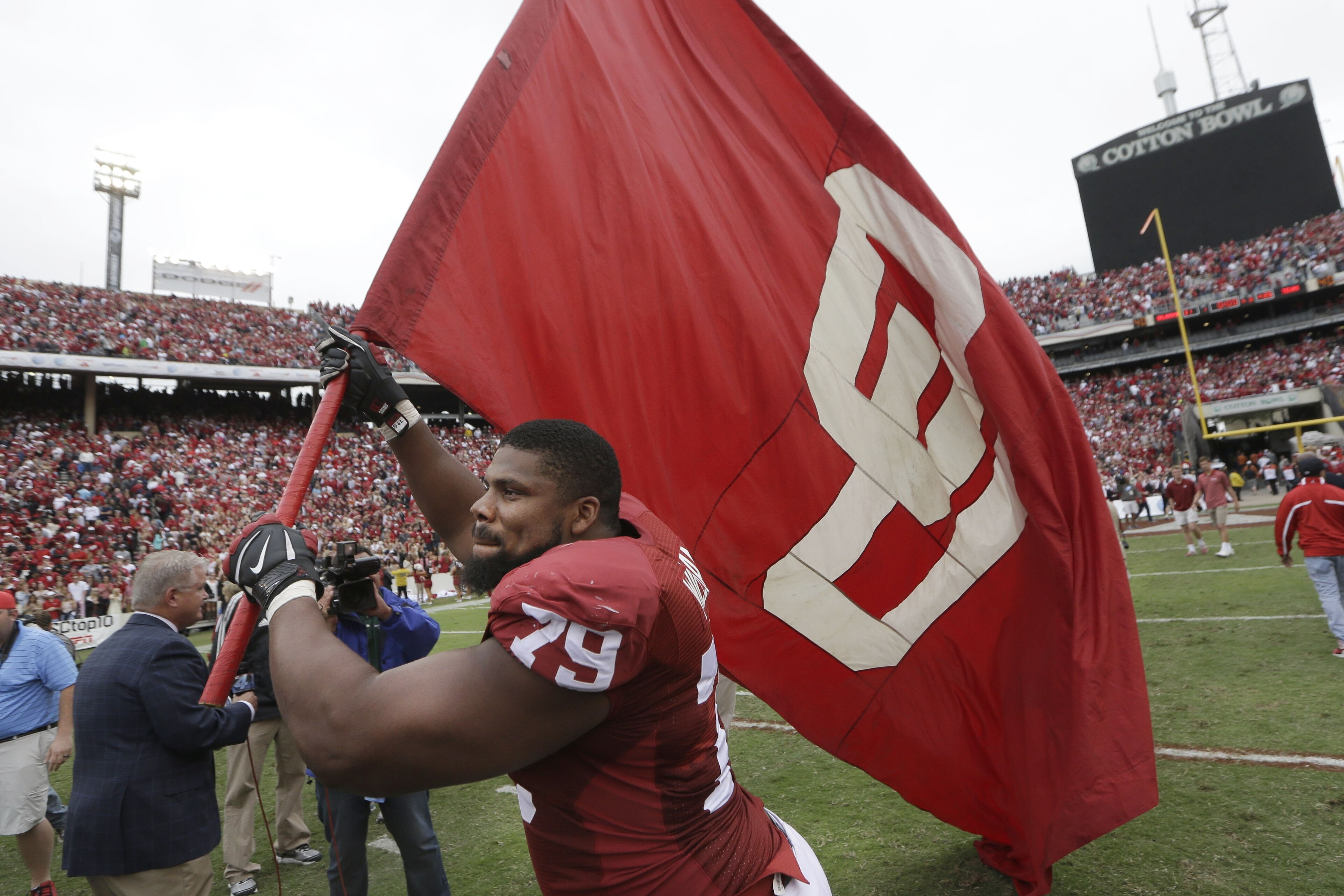 Oklahoma offensive tackle Daryl Williams (79) runs with a flag on the field after an NCAA college football game against Texas at the Cotton Bowl, Saturday, Oct. 11, 2014, in Dallas. (AP Photo/LM Otero)