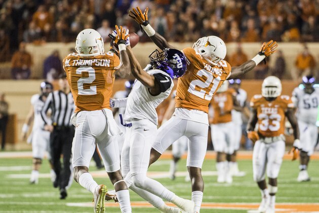 TCU's Kolby Listenbee (7) and Texas' Mykkele Thompson (2) and Duke Thomas (21) reach to catch a pass intended for Listenbee during the second half of an NCAA college football game, Thursday, Nov. 27, 2014, in Austin, Texas. (AP Photo/Ashley Landis)