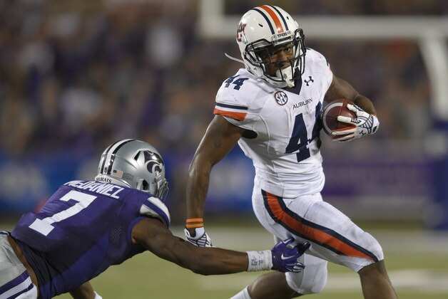 Auburn Tigers running back Cameron Artis-Payne (44) tries to avoid Kansas State Wildcats defensive back Danzel McDaniel (7) during an NCAA college football game Thursday, Sept. 18, 2014 in Manhattan, Kan. (AP Photo/Reed Hoffmann)