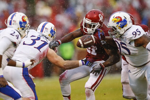 Nov 22, 2014; Norman, OK, USA; Kansas Jayhawks linebacker Ben Heeney (31) causes Oklahoma Sooners running back Keith Ford (21) to fumble the ball during the first half at Gaylord Family - Oklahoma Memorial Stadium. Mandatory Credit: Kevin Jairaj-USA TODAY Sports
